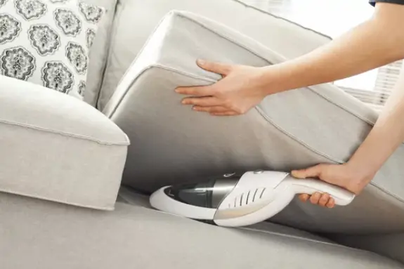 a person cleaning the sofa