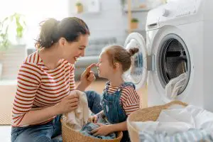 Mother and daughter in front of a washing machine