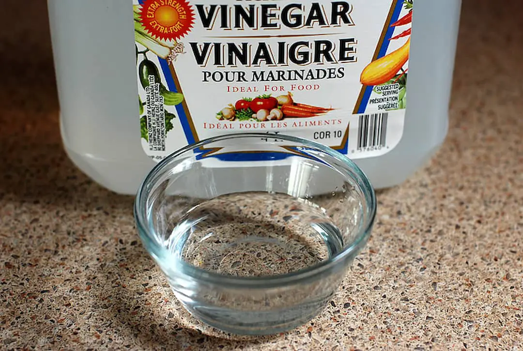 a bottle of vinegar and a glass dish