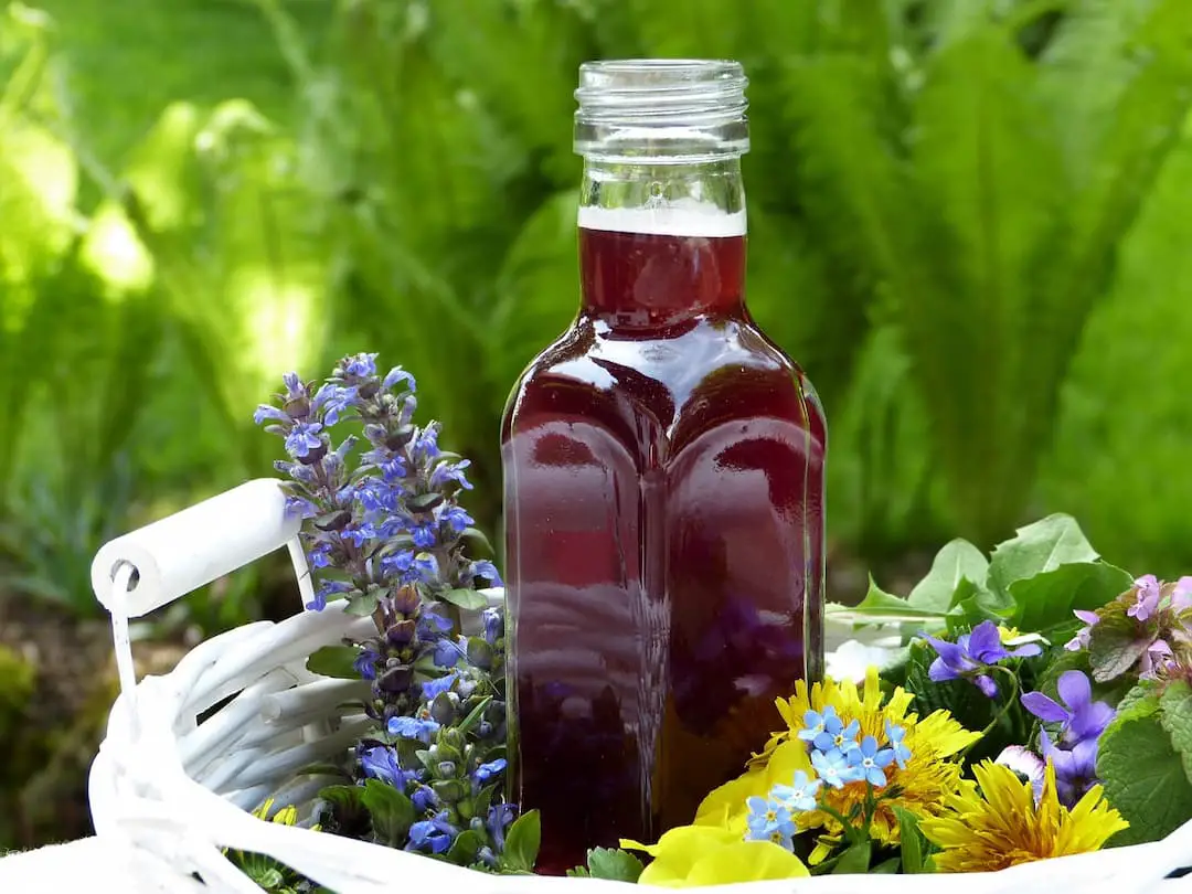 a bottle of vinegar and flowers in the basket